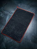 Black towel with red trim on a textured dark surface